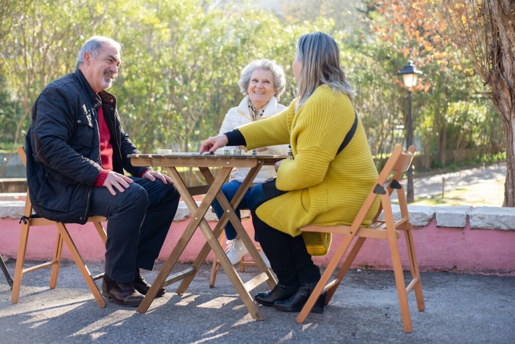 neighbours sitting around table plating dominos